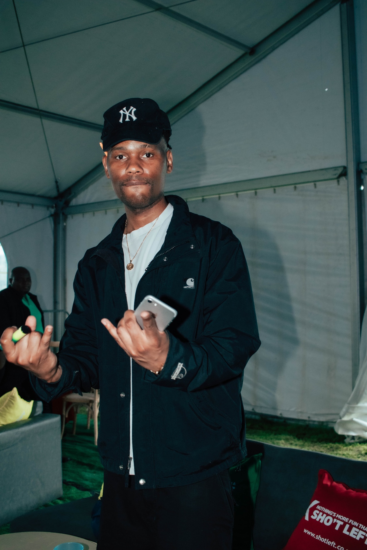 Artist backstage in Carhartt jacket and NY cap