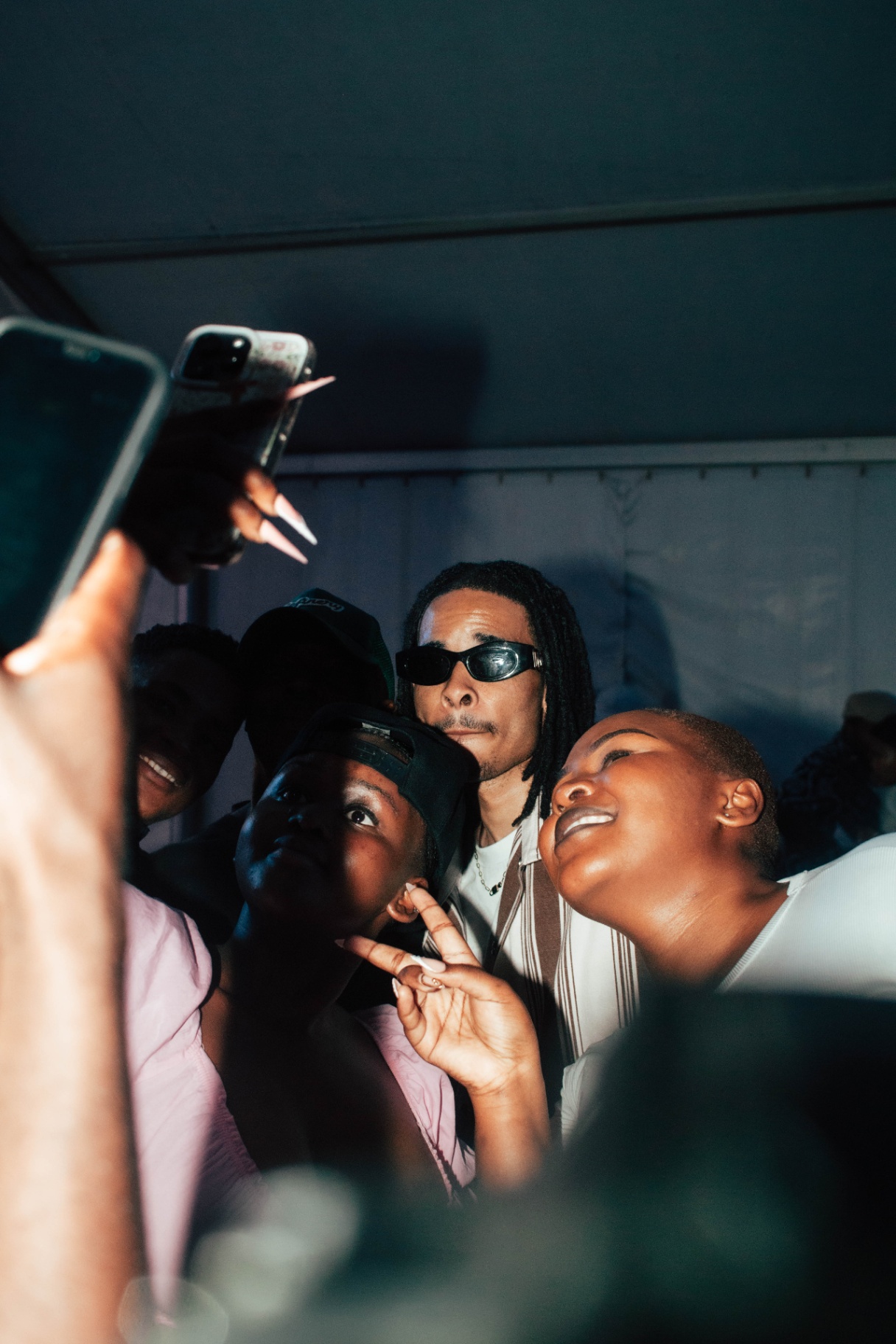 Group selfie with artist and fans backstage