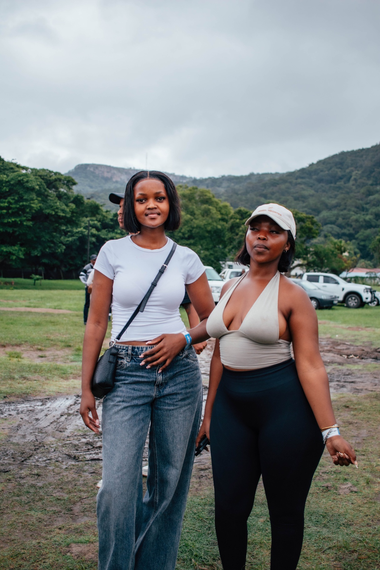 Two festival-goers with the Wild Coast hills behind them