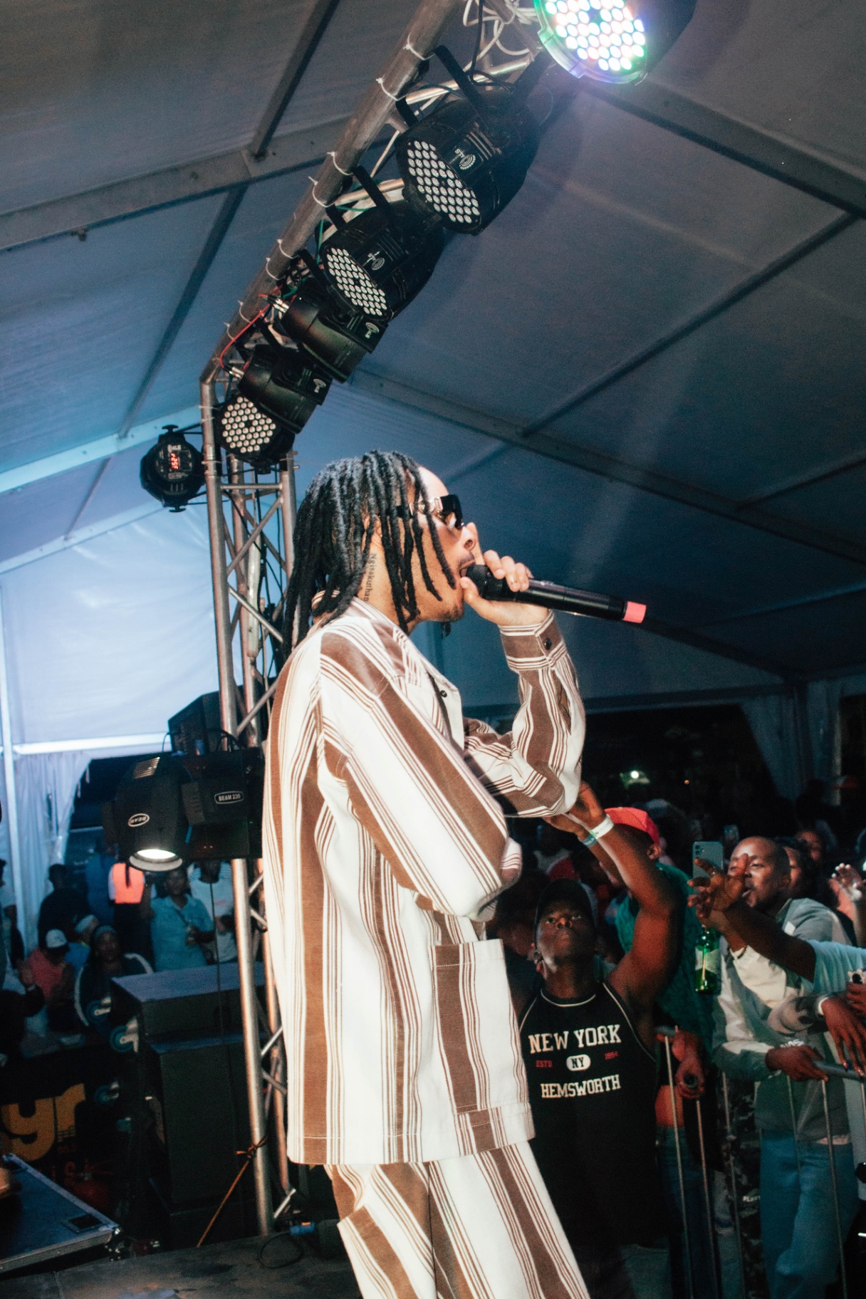Side profile of artist performing with crowd reaching up
