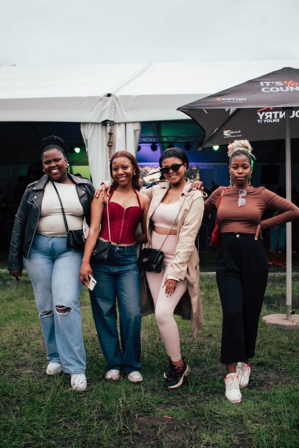 Four friends posing together outside the main tent
