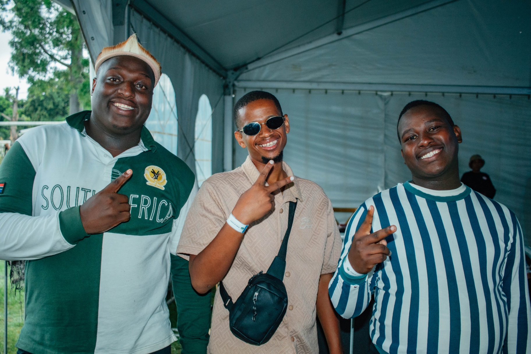 Three friends pointing at each other inside the tent