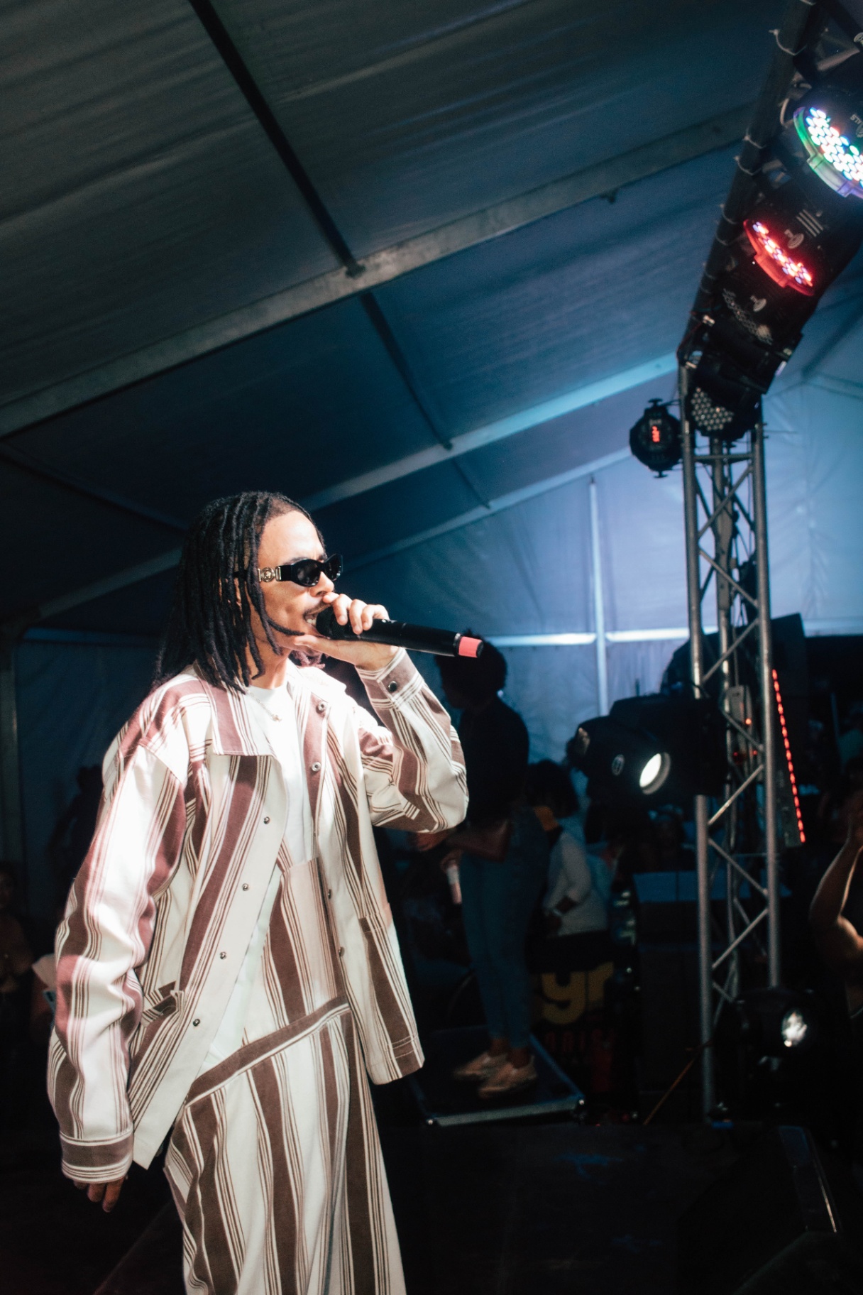 Artist on stage with blue tent lighting overhead